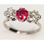 A three stone diamond and ruby ring, the central oval cut ruby approx. 0.93 carats, total approx.