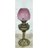 A Victorian brass oil lamp with etched cranberry glass shade, height 69cm.