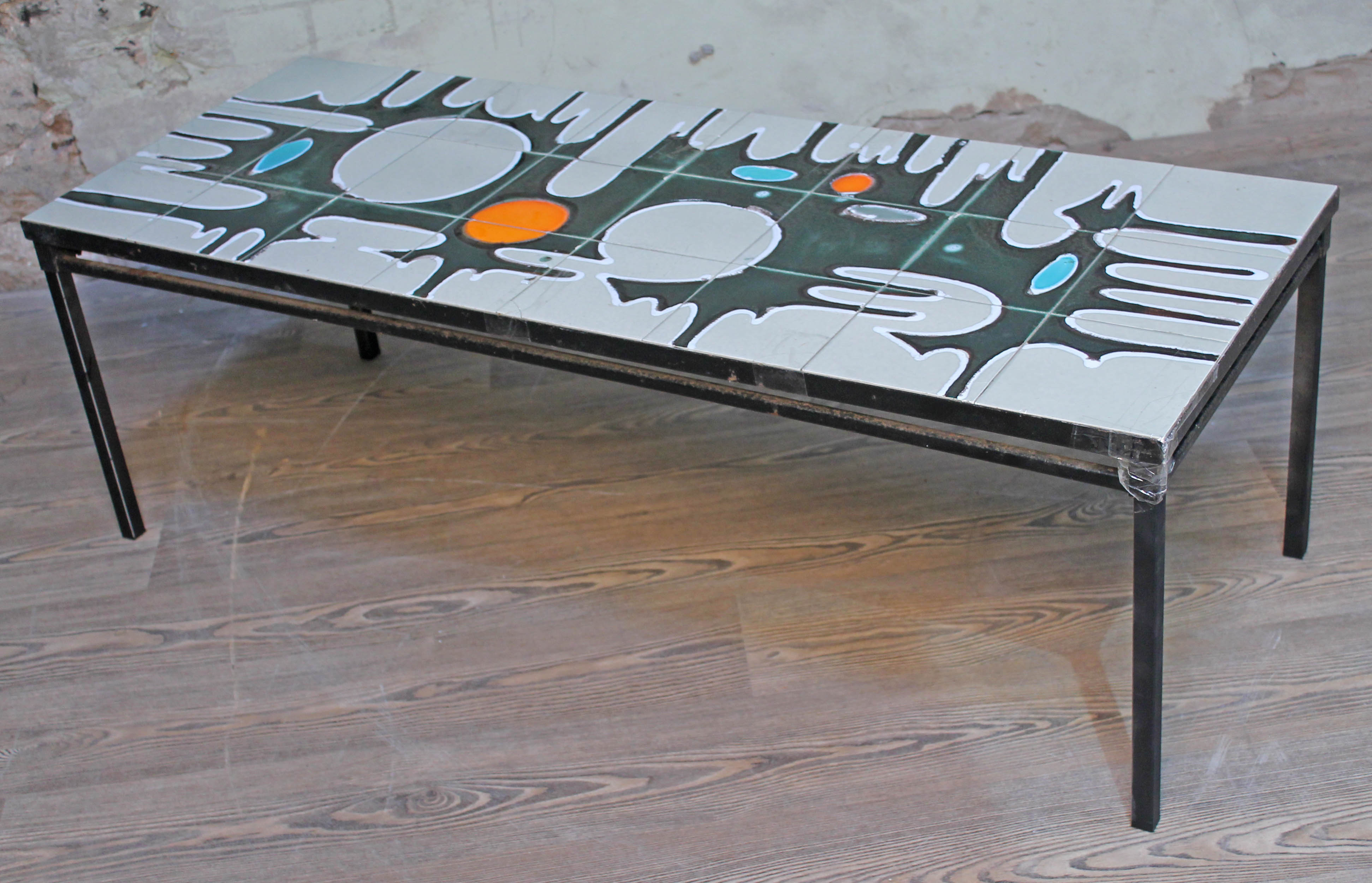 A retro abstract tile top coffee table, length 122.5cm. Condition - various cracks to tiles.