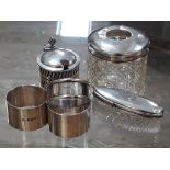 A group of hallmarked silver comprising two silver topped glass jars, a silver mustard and three