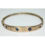 A diamond sapphire and blue stone bracelet, yellow metal unmarked, diam. 53mm, gross wt. 7.6g.