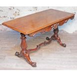 A 19th century rosewood writing table having moulded scroll frieze, pedestal legs supported by