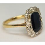 A sapphire and diamond ring, the central rectangular cut stone approx. 5.43ct, the surrounding