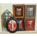 A group of six crucifixes in domed glass frames.