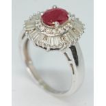 A contemporary Art Deco style ruby and diamond cluster ring, the oval cut ruby set within a surround