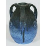 A Ruskin Arts & Crafts pottery three handed vase with embossed rosettes and drip decoration on