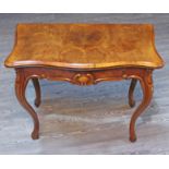 An early 20th century Continental burr walnut games table of serpentine form with fold over top,
