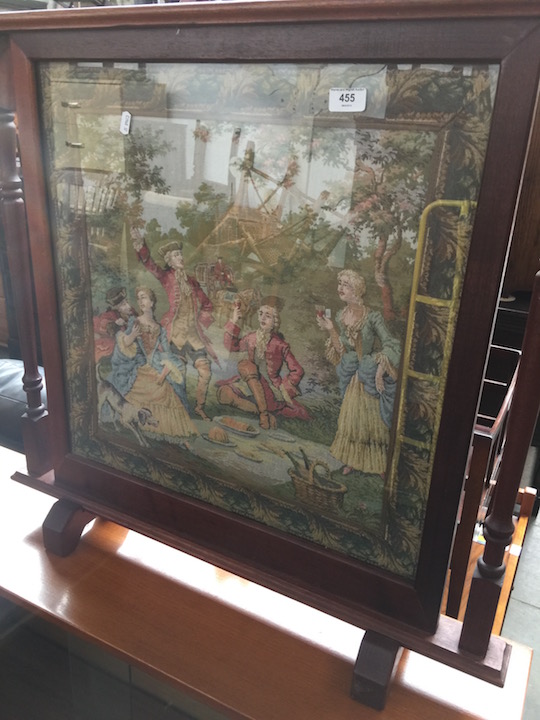 A tapestry fire screen.