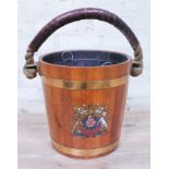 A Victorian fire bucket with leather bound rope handle, brass bound with transferred coat of arms to