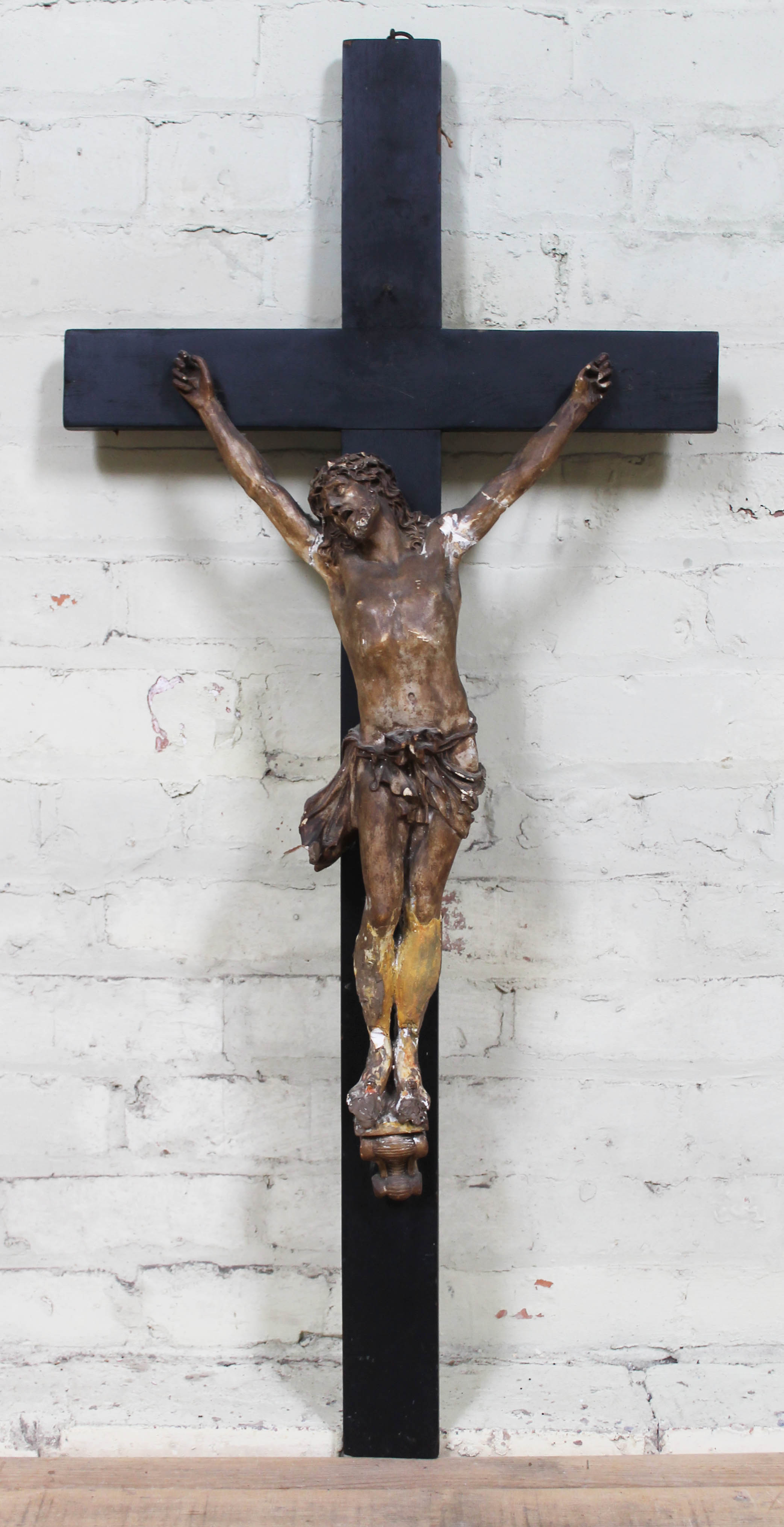 A large plaster and wood crucifix, length 110cm.