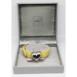 A Lalique yellow leather bracelet having applied glass heart with white metal mounts and set with