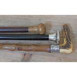 A group of three walking sticks, one with hallmarked silver top, one with knobbly shaft, white metal