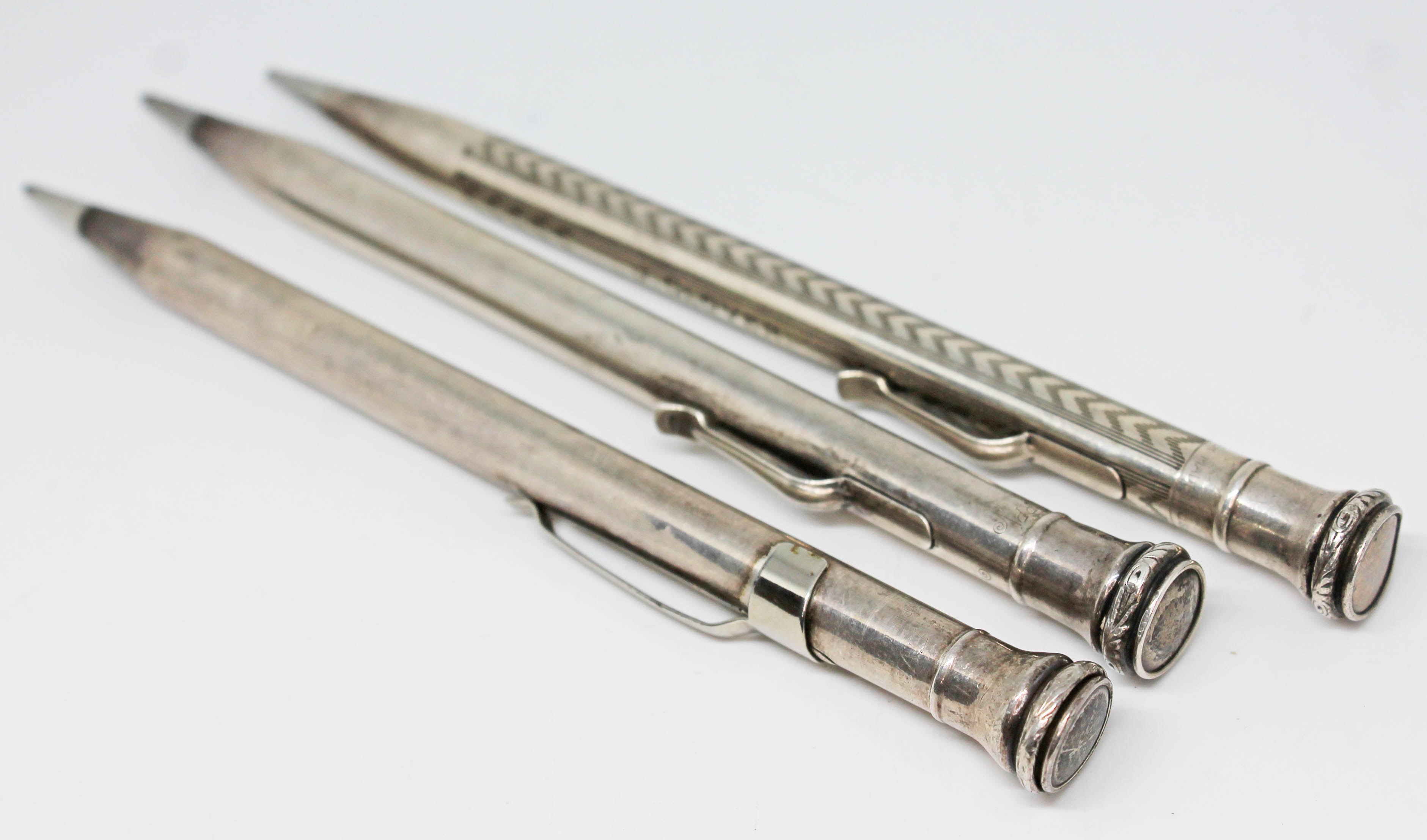 A group of three silver propelling pencils, 925 import marks.