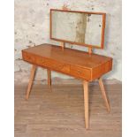 An Ercol Blonde elm and beech dressing table, mirror back, three drawers with splayed legs, width