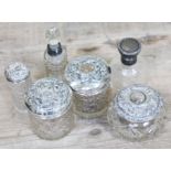 A group of six hallmarked silver topped/mounted jars and scent bottles.