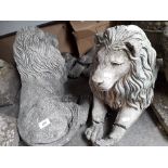 Garden ornaments, two reclining lions (one is damaged)