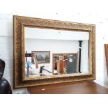 A large gold framed bevelled edge mirror