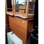 A teak drop leaf table and 2 chairs