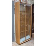 An Ercol blonde elm glazed display cabinet bookcase, width 92cm, depth 31cm & height 214cm.