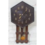 An Arts & Crafts style drop dial oak wall clock with brass numerals.