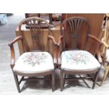 A pair of George III and later mahogany armchairs with embroidered seats.