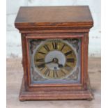 An oak cased mantle clock having brass and silvered dial with Roman Numerals and four pillar brass