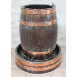 A copper bound planter of barrel form with loop handle and stand, height 53cm.