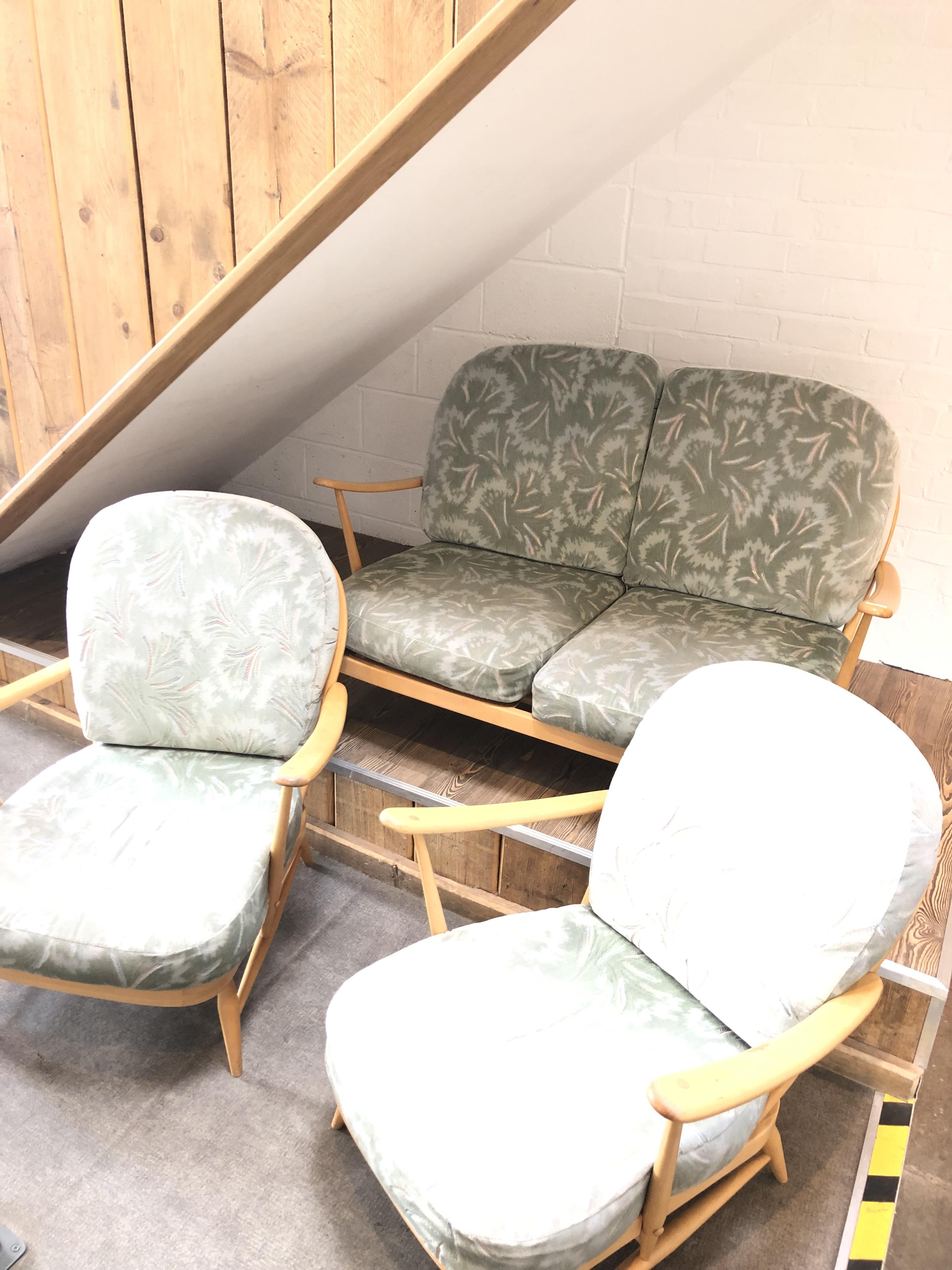 An Ercol blonde Windsor three piece suite comprising a settee and a pair of armchairs