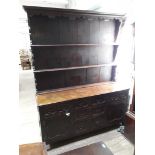 An oak dresser circa 1900 with plate rack back, geometric drawer fronts and brass handles, width