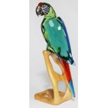 A Swarovski Paradise Birds parrot on naturalistically formed wooden stand, height 23cm.