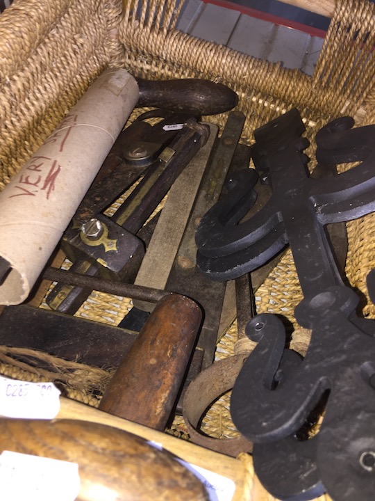 A basket of vintage tools, many made of ebony and brass.