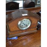 An Edwardian oak mantle with domed top, steel dial with gothic numerals, brass pillars and classical