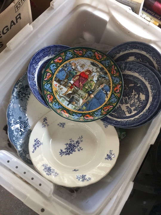 A crate of pottery and some photo frames