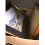 A box of paintings and prints.