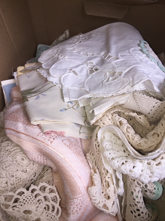 A box of linen to include macrame, doilies, etc.