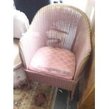 A pink Lloyd Loom style chair.