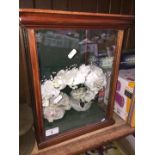 A glazed small cabinet containing a tiara / headpiece.