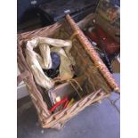 A wicker fishing basket with reels and tackle