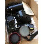 A box of camera equipment including Canon AE1 program, extra lenses and power winder