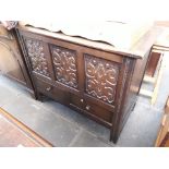 A 1930s oak mule chest with carved panels