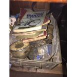 A tin box of motorcycle spares and related books.