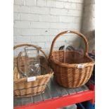 Two wicker shopping baskets with two glass vases