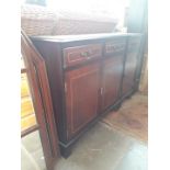 Two reproduction mahogany cabinets and a brass headboard.