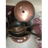 A set of 4 copper and brass pans