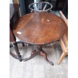 A Georgian oak tripod table on pad feet