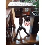 A carved tripod table