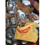 A table top of kitchen utensils, cooking pans, Pyrex, pressure cooker, stainless steel items,