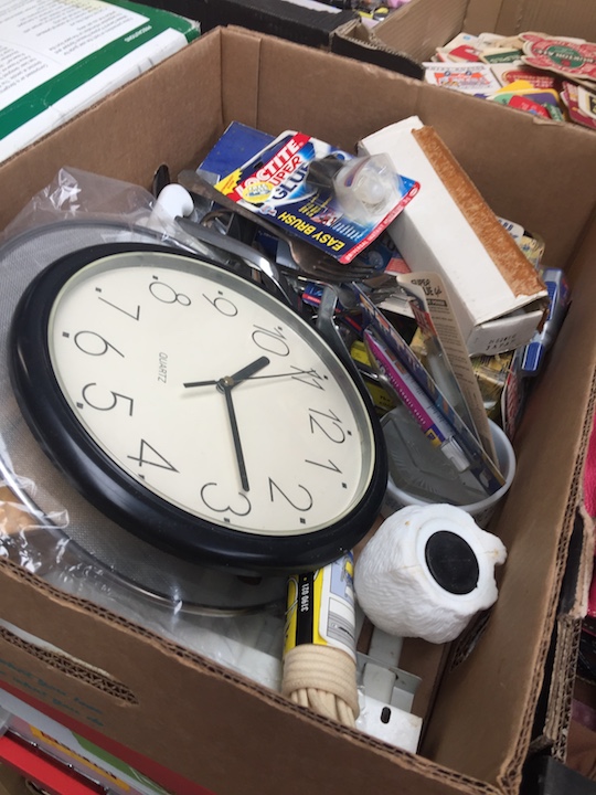 A box of misc including a knife block, tubes of adhesive, wall clock etc