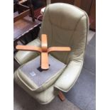 A cream leather swivel armchair with matching stool