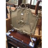 A brass ornate fire screen